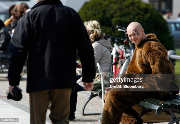 Street performer dressed as the Berlin Bear, the city mascot, takes a break from entertaining tourists in front of the Brandenburg Gate in Berlin,...