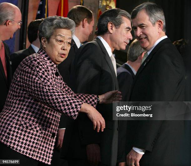 Chinese Vice Premier Wu Yi gestures to U.S. Agriculture Secretary Mike Johanns while setting up for a ?family photo? with the delegates attending the...