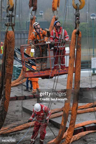 Final preparations are made as a replica of Captain Cook's famous ship, HM Bark Endeavour, is made ready to be hoisted by crane over the lock gates...