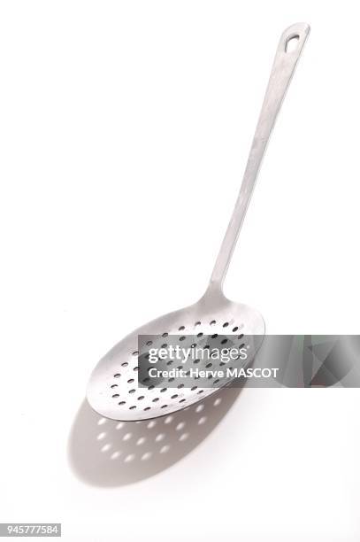 Slotted spoon on white back ground. Ecumoire sur fond blanc.