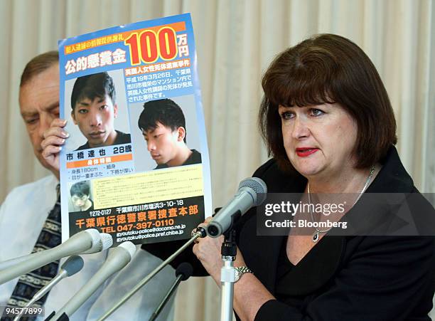 Julia Hawker, right, holds up a posted of the suspect wanted in connection to her daughter Lindsay's murder, flanked by her husband Bill, during a...