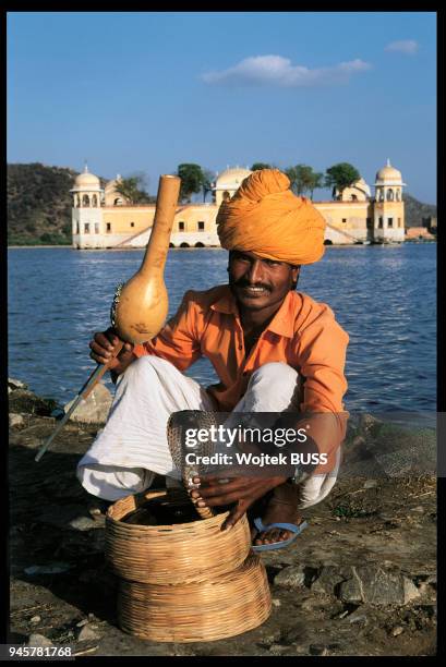 Charmeur de cobra devant le palais Jal Mahal ? Jaipur, Inde.