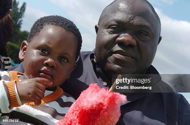 Celestin Banya, a resident of Clichy-sous-Bois, poses with his son at the city fete in Clichy-sous-Bois, near Paris, France, on Sunday, Sept. 9,...