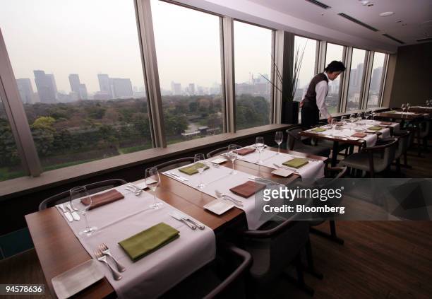 Waiter sets the tables for lunch at the Restaurant Francais & library Cafe Argo in Tokyo, Japan, on Tuesday, March 27, 2007. In the city center, Argo...