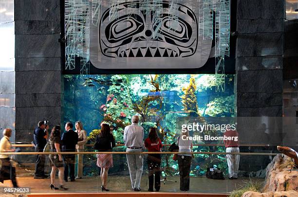 Passengers at Vancouver International Airport look at fish in an aquarium in the new International Terminal of the airport in Vancouver, British...