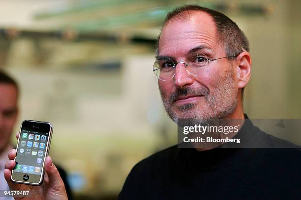 Steve Jobs, chief executive officer of Apple Corp., holds an iPhone at the Apple store in Regent Street, London, U.K., on Tuesday, Sept. 18, 2007....