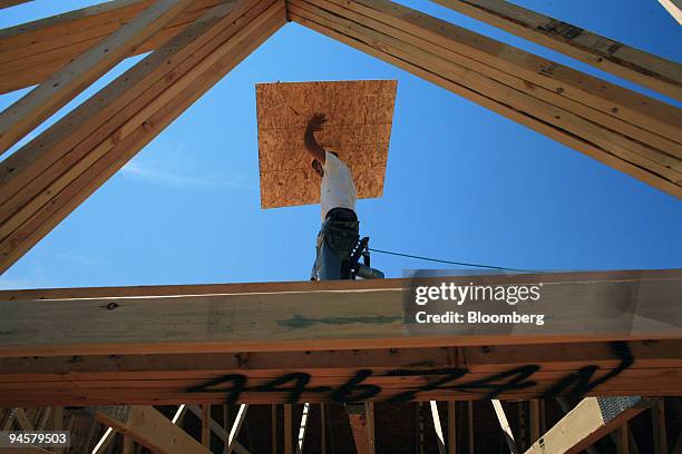 Luis Gusman puts the roof on a single family home in Thornton, Colorado, Tuesday, July 17, 2007. A slowdown in the U.S. Housing market and losses in...