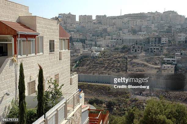 Shuafat, a Palestinian refugee camp, sits in the distance as the West Bank barrier divides it from the Jewish neighborhood of Pisagat Ze'ev, in...