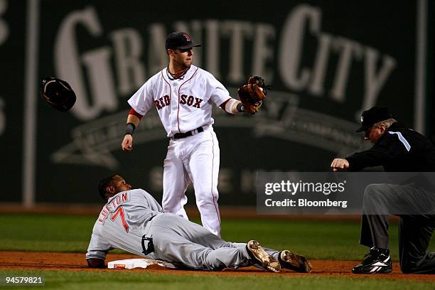 Dustin Pedroia of the Boston Red Sox, standing, tags out Kenny Lofton of the Cleveland Indians in the seventh game of the American League...