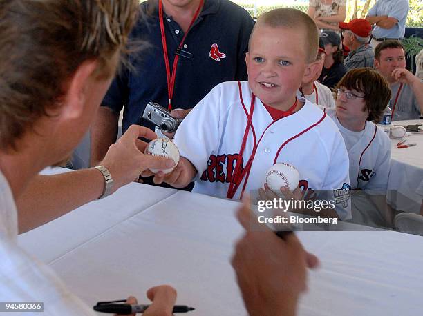 Matthew Hedlund, from Wellesley, Massachusetts, gets an autograph from Boston Red Sox pitcher Mike Timlin during a post-spring training game barbeque...