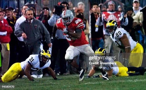 Ohio State University tailback Antonio Pittman, No. 25, avoids University of Michigan tacklers Brandent Englemon, No.37, Trent Morgan, No. 14, and...