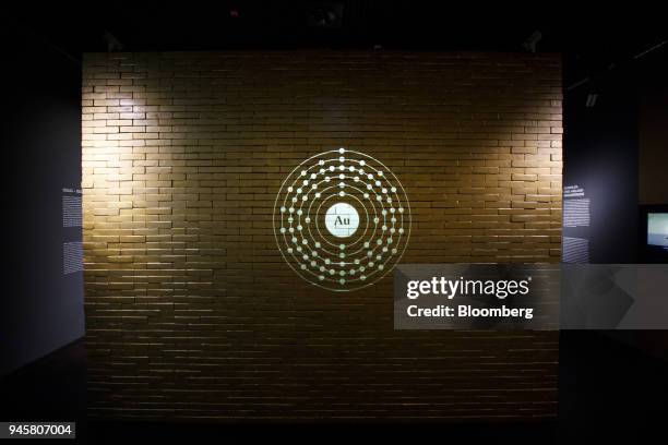 The chemical symbol for gold is projected on a wall of imitation gold bars in the German national gold reserve exhibition inside the Deutsche...