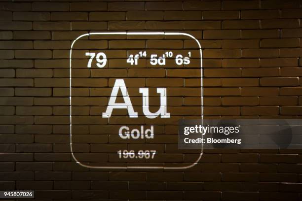 The chemical symbol for gold is projected on a wall of imitation gold bars in the German national gold reserve exhibition inside the Deutsche...