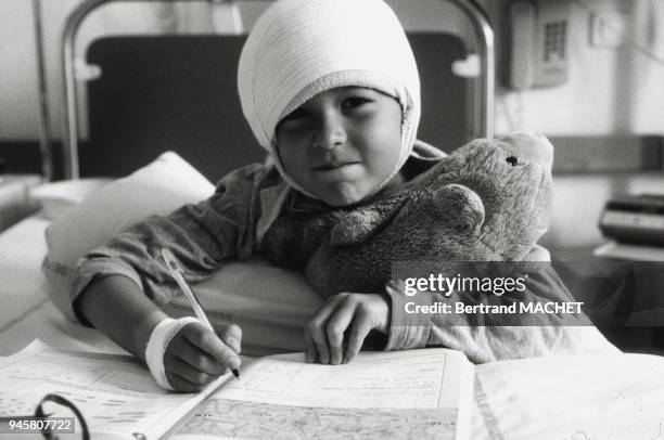 Enfant faisant ses devoirs dans une chambre d'h?pital.