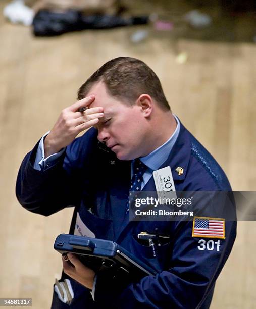 Floor trader James Duffy touches his forehead as he cradles a phone on his shoulder while working at the New York Stock Exchange Exchange in New...