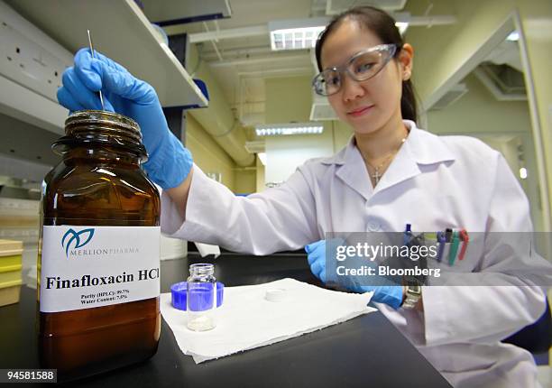 Merlion Pharmaceuticals Pte. Scientist measures some of the company's Finafloxacin drug, developed to fight Helicobacter pylori infections which...