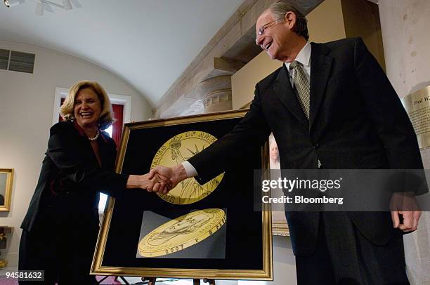 Representative Michael Castle of Delaware, right, shakes hands with Representative Carolyn Maloney of New York in front of a drawing representing the...