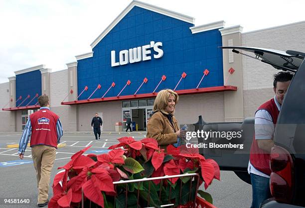 Customer Ann Healy, second from the right, is assisted by Lowe's employees as she loads her car after shopping at the Lowe's store in Dedham,...