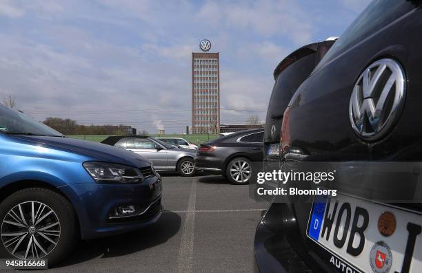 The Volkswagen AG headquarters stand beyond automobiles in an employee parking lot in Wolfsburg, Germany, on Friday, April 13, 2018. Volkswagen AGs...