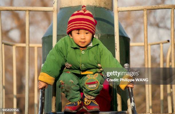 PETIT GARCON JOUANT DANS UN PARC, PEKIN, CHINE.