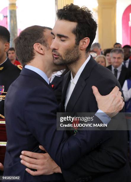 French President Emmanuel Macron congratulates France's five-time Olympic champion Martin Fourcade after he was awarded Officier of the Legion of...