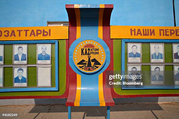 Kazatomprom sign and pictures of employees hang outside a building at the East Mynkuduk uranium mine in Kyzemshek, Kazakhstan, on Thursday, Oct. 18,...