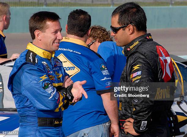 Former Formula 1 driver Juan Pablo Montoya, right, speaks with former open wheel driver John Andretti during practice at the Homestead Miami...