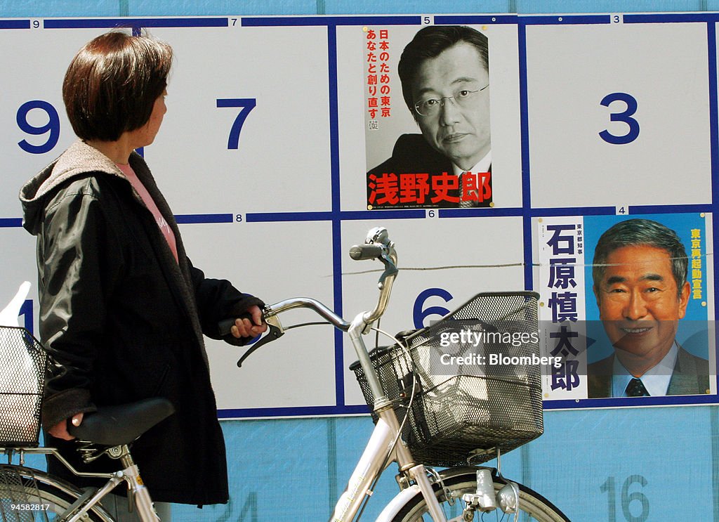 A pedestrian looks at a campaign poster of Shintaro Ishihara