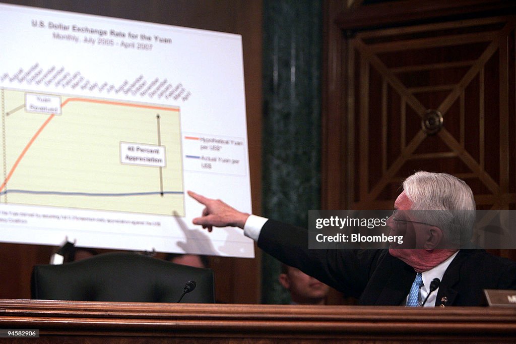 Senator Jim Bunning points to a chart on the U.S. Dollar Exc