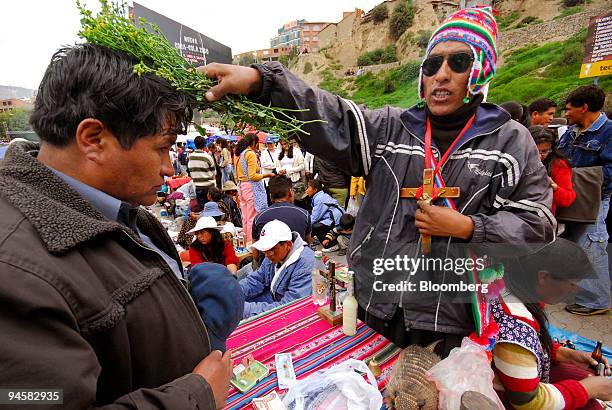 Bolivian man receives a blessing of his reproduced U.S. Dollars during the Alasita festival in La Paz, Bolivia, on Wednesday, January 24, 2007. The...