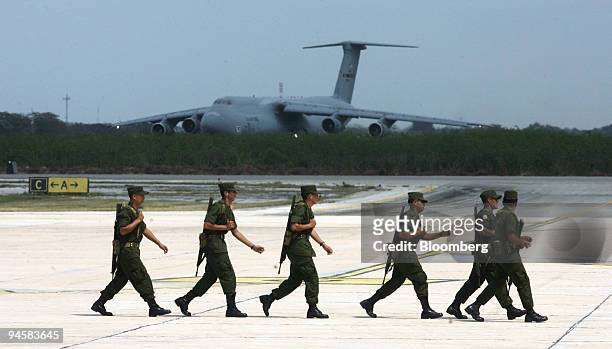 Soldiers patrol the airport in Merida, Yucatan, Mexico, March 10, 2007 as a U.S. Air Force Galaxy C-5 plane unloads security personnel and equipment...