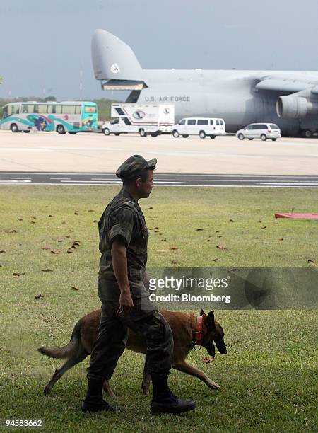 Soldier and his dog patrol the airport in Merida, Yucatan, Mexico, March 10, 2007 as a U.S. Air Force Galaxy C-5 plane unloads security personnel and...