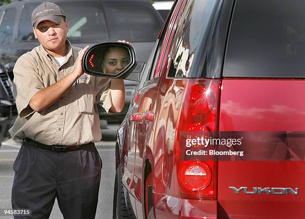 Salesman Oscar Herrera describes the features of a new GMC Yukon to Salina Hernandez at the Stevens Creek GM dealership in Santa Clara, California,...