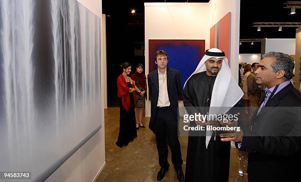 Sundaram Tagore, right, of Sundaram Tagore Gallery in New York City explains the techinque used in a painting to His Excellency Dr. Omar Bin...