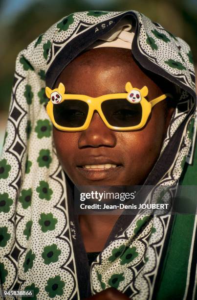 JEUNE FEMME UN JOUR DE FESTIVAL AVEC DES LUNETTES DE SOLEIL A ZANZIBAR.