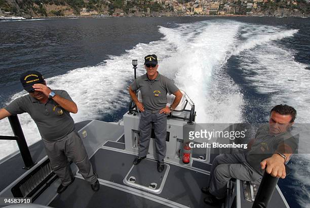 Three officers of the Guardia di Finanza police, look for illegal building along the Amalfi coast, Italy, on Friday, Sept. 14, 2007. The villas and...