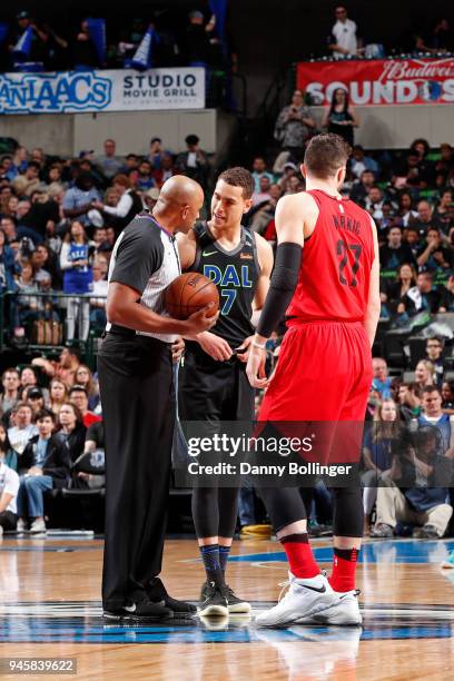 Referee Kevin Cutler speaks to Dwight Powell of the Dallas Mavericks and Jusuf Nurkic of the Portland Trail Blazers before tip off during the game on...