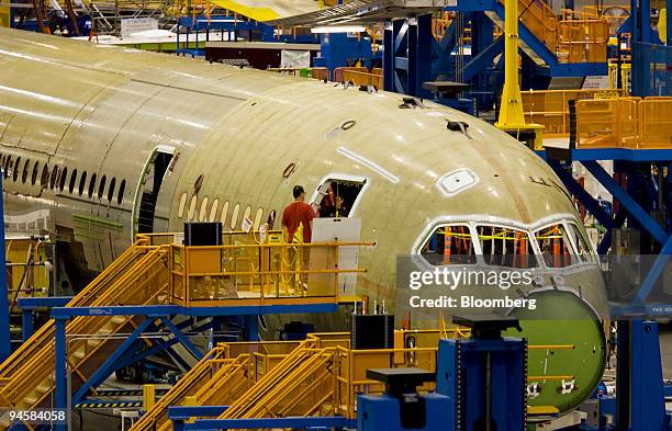 Boeing worker stands in the doorway of a Boeing 787 Dreamliner under construction at the Boeing Co. Everett plant in Washington, on Saturday, July 7,...
