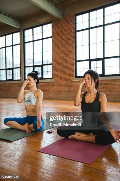 pranayama breathing exercises. women practicing yoga position - pranayama stock pictures, royalty-free photos & images