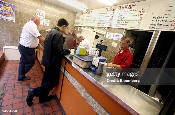 Customers queue at a fish and chip shop in Saffron Walden, Essex, UK. Thursday, July 12 2007. Rising prices for food, from fish and chips in Britain...