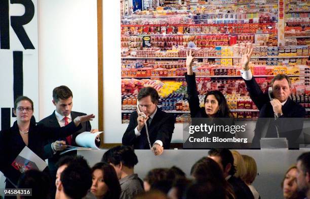 Bids are made by phone underneath Andreas Gursky?s ?99 Cent II Diptychon? at a contemporary art auction at Phillips de Pury & Company in New York on...