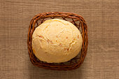 Pao de Queijo is a cheese bread ball from Brazil. Also known as Chipa, Pandebono and Pan de Yuca. One snack in basket over wood table, flat lay.