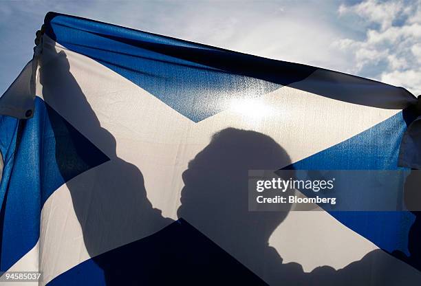 An unidentified supporter of Scottish Independence proudly displays the Saltire flag, the national flag of Scotland in Edinburgh, Scotland,...