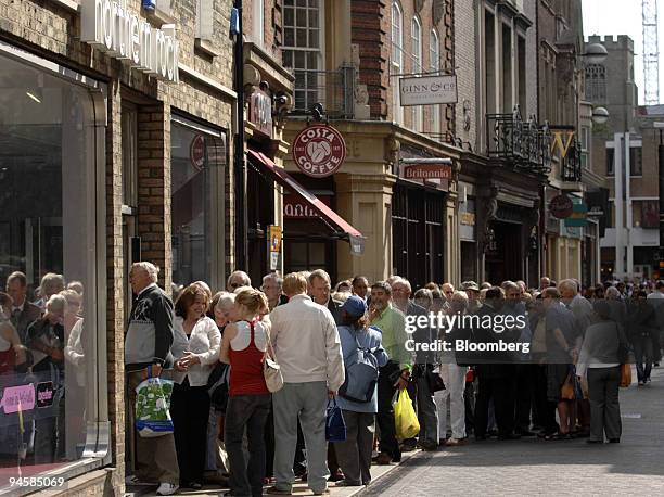 Northern Rock customers line up to withdraw their savings after the company was bailed out by the Bank of England to borrow funds, at one of the...