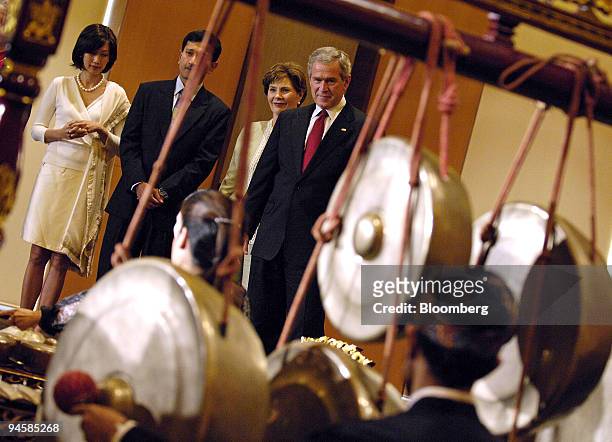 American President George W. Bush and First Lady Laura Bush listen to a Gamelan emsemble perform a traditional number during their visit to the Asian...