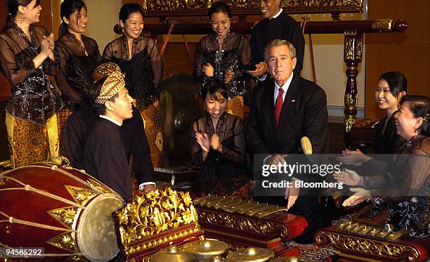 American President George W. Bush is applauded by Gamelan musicians after he tries his hands on a traditional instrument during a visit to the Asian...