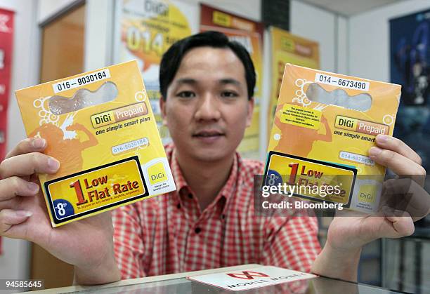Dealer displays Digi. Com Bhd. Products at his shop in Subang Jaya, Malaysia, on Tuesday, Jan. 30, 2007. Digi. Com Bhd. Is expected to post earnings...