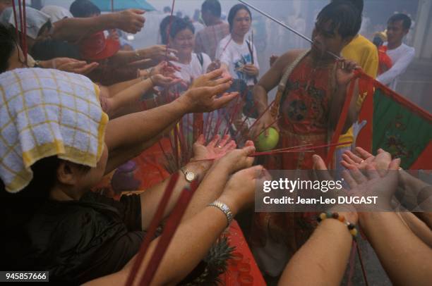 Medium with pierced cheeks giving his blessing during a procession. This vegetarian festival takes place for the first 9 days of the 9th lunar month...