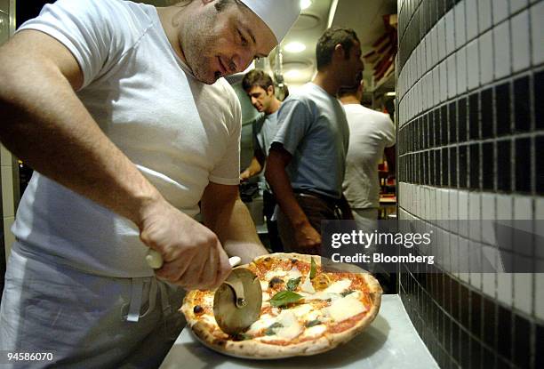Chef slices up a Margherita pizza at Pizze e Birra in Sydney, Australia, on Monday, May 21, 2007. Pizze e Birra is enough to make me move house just...