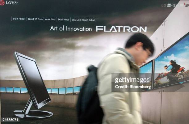 Pedestrian walks past the front of an LG Telecom Ltd. Advertising board at a subway station in Seoul, South Korea, on Tuesday, Jan. 30, 2007.LG...